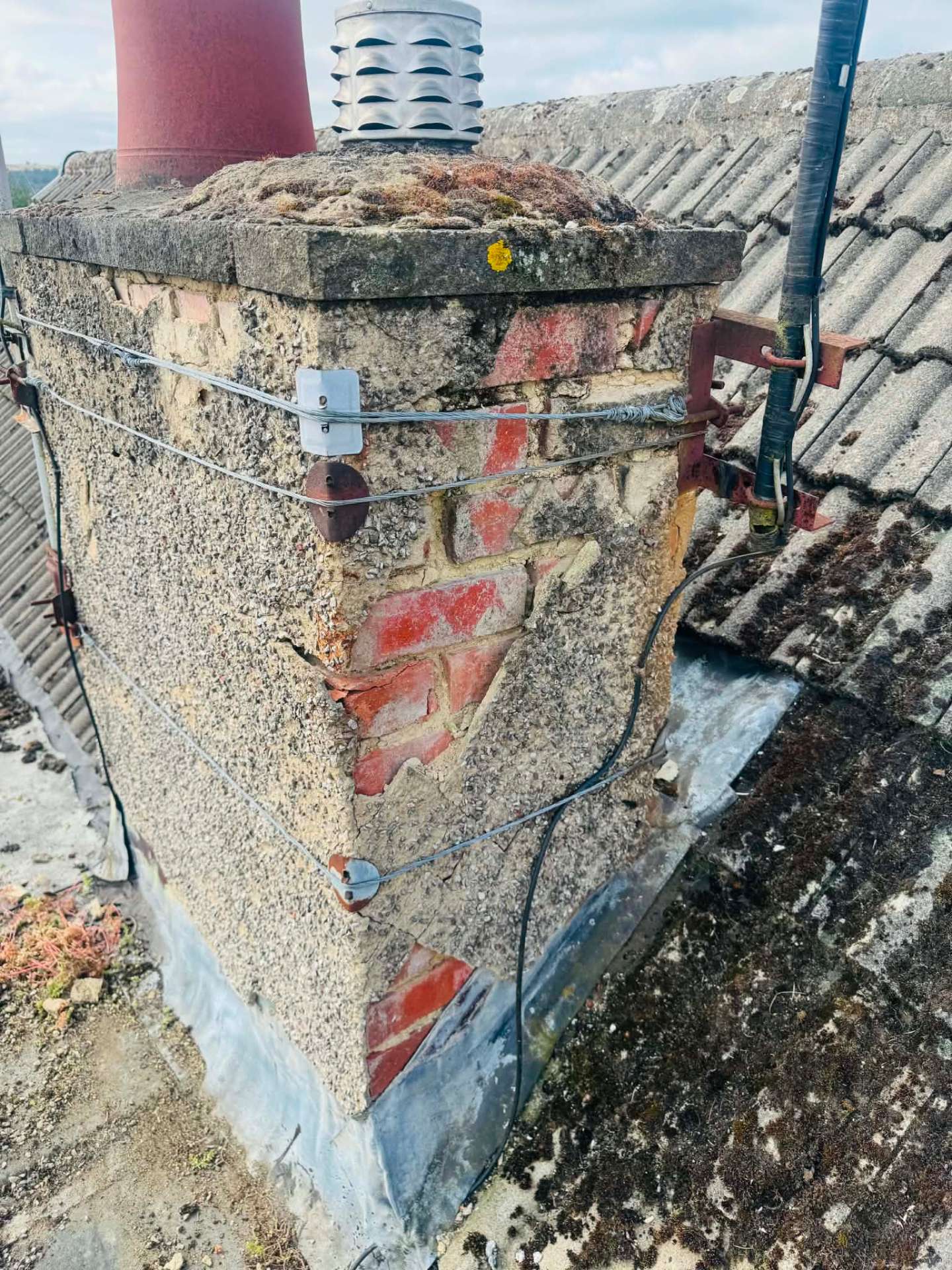 Chimney stack before work, with spalled brickwork, failed pointing and loose flaunching