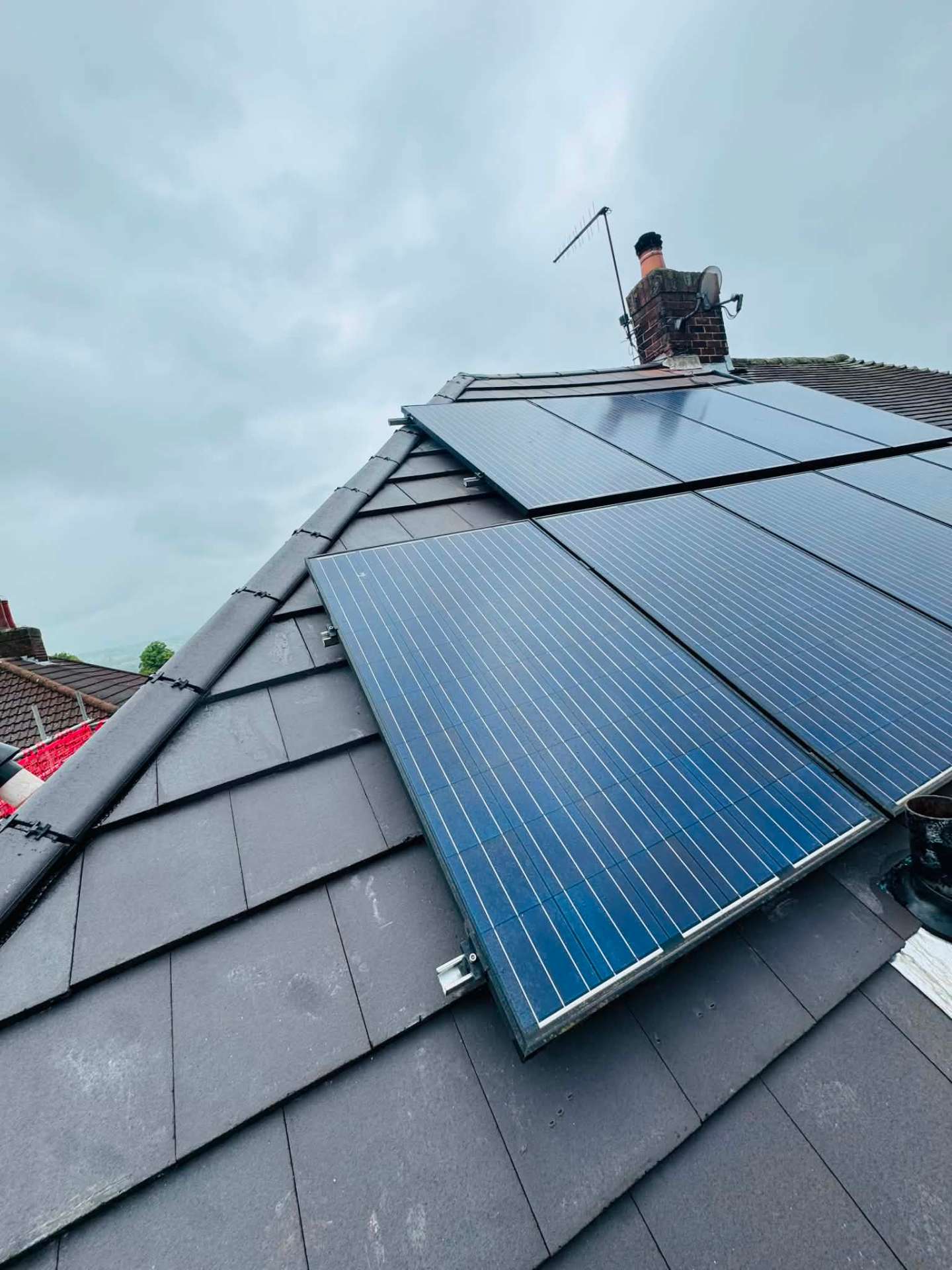 New roof tiles laid neatly around an existing solar panel array