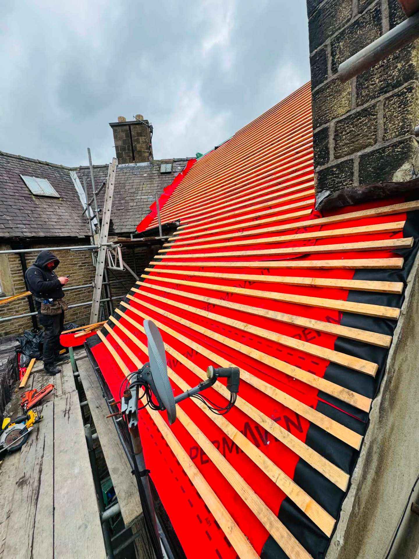 Red breathable membrane and new battens fitted to a Yorkshire stone property mid re-roof