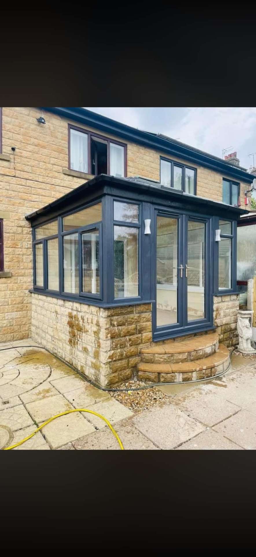 Completed conservatory with anthracite grey frames, French doors, stone base and new stone steps